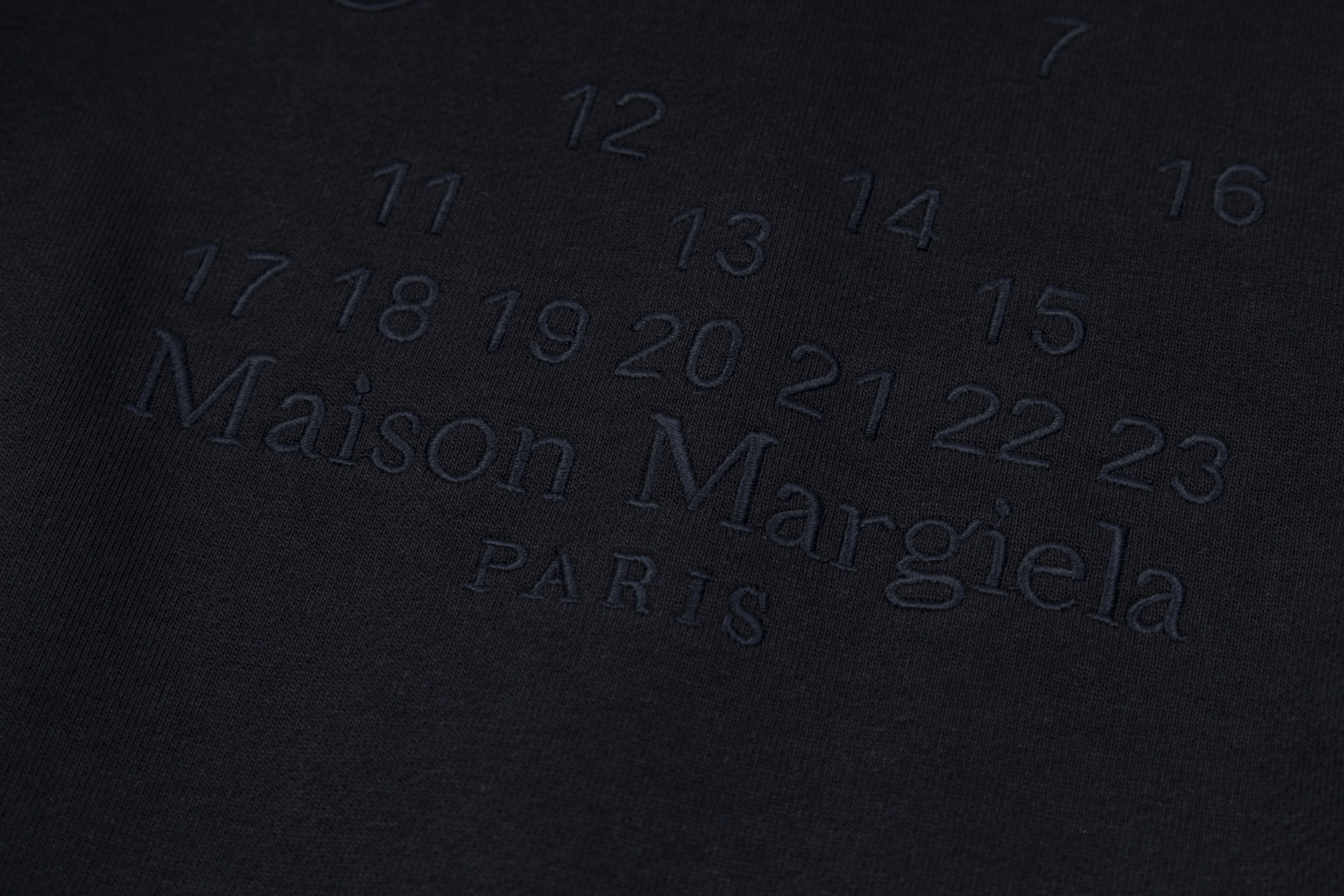Dark navy fabric with embossed Maison Margiela Paris logo lettering