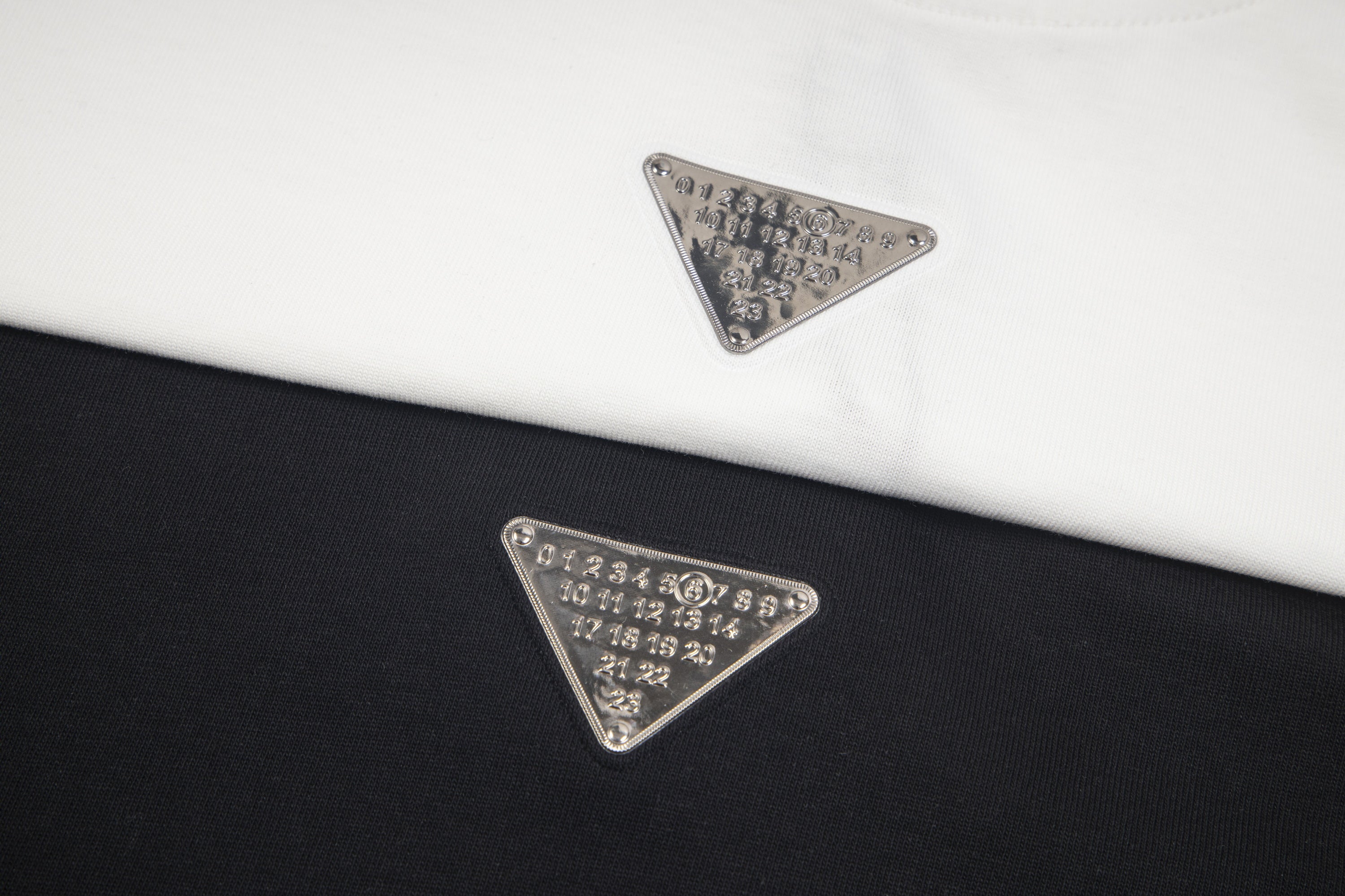 Maison Margiela embroidered triangular logo on T-shirt fabric