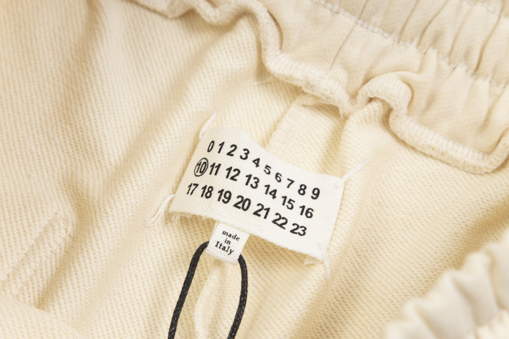 Beige Maison Margiela shorts care label with numbered size tags and drawstring cord.