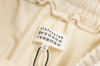 Beige Maison Margiela shorts care label with numbered size tags and drawstring cord.
