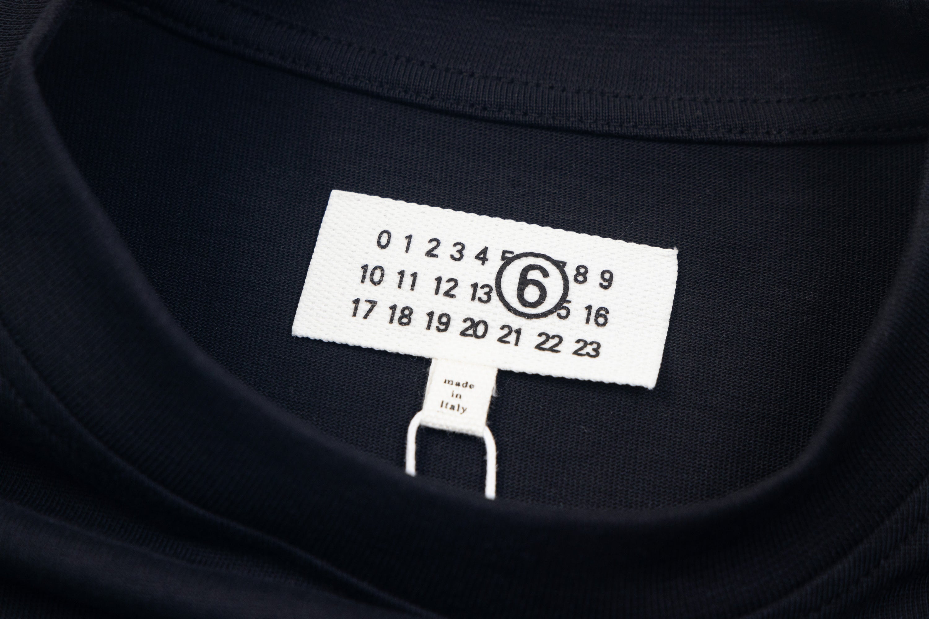 Navy crewneck T-shirt neckline with size label and numeric chart