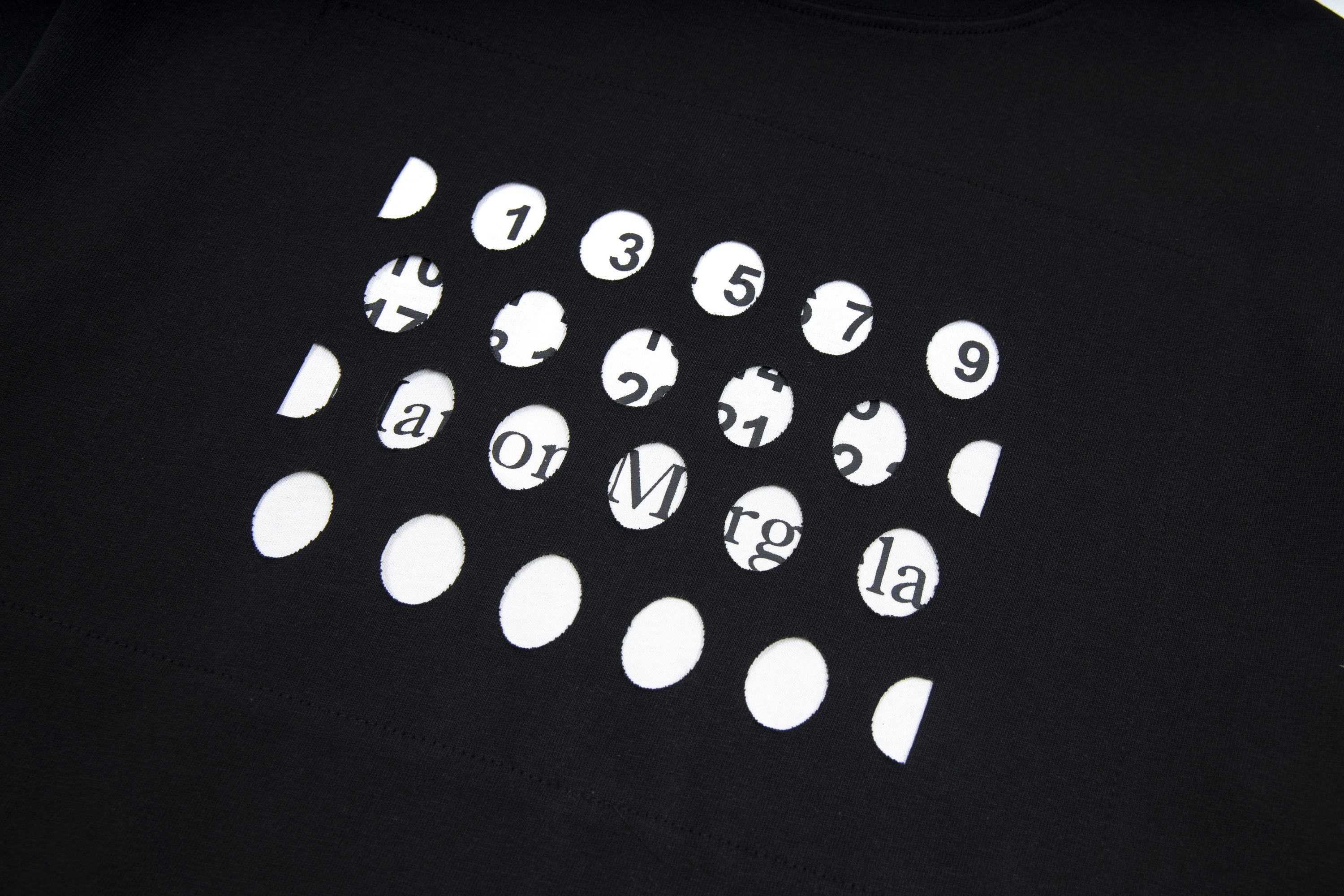 Black T-shirt with white graphic print of numbered faces and symbols