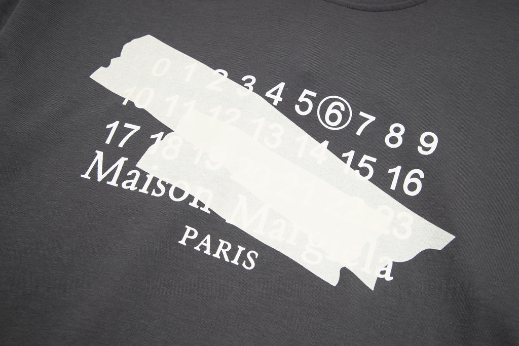 Black T-shirt front print close-up with number graphic and Maison Margiela Paris text