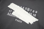 Black T-shirt front print close-up with number graphic and Maison Margiela Paris text
