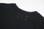 Black crew-neck T-shirt with small distress holes near shoulder