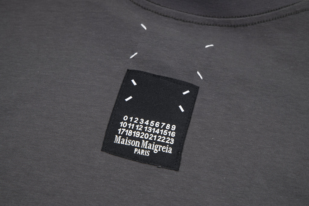 Black T-shirt neckline label with printed number graphic and Maison Margiela Paris text