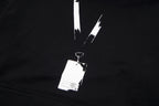 Black pullover hoodie close-up with drawstrings and brand hang tag on the chest