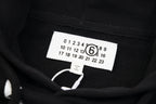 Black pullover hoodie interior with size label and care information tag near neckline