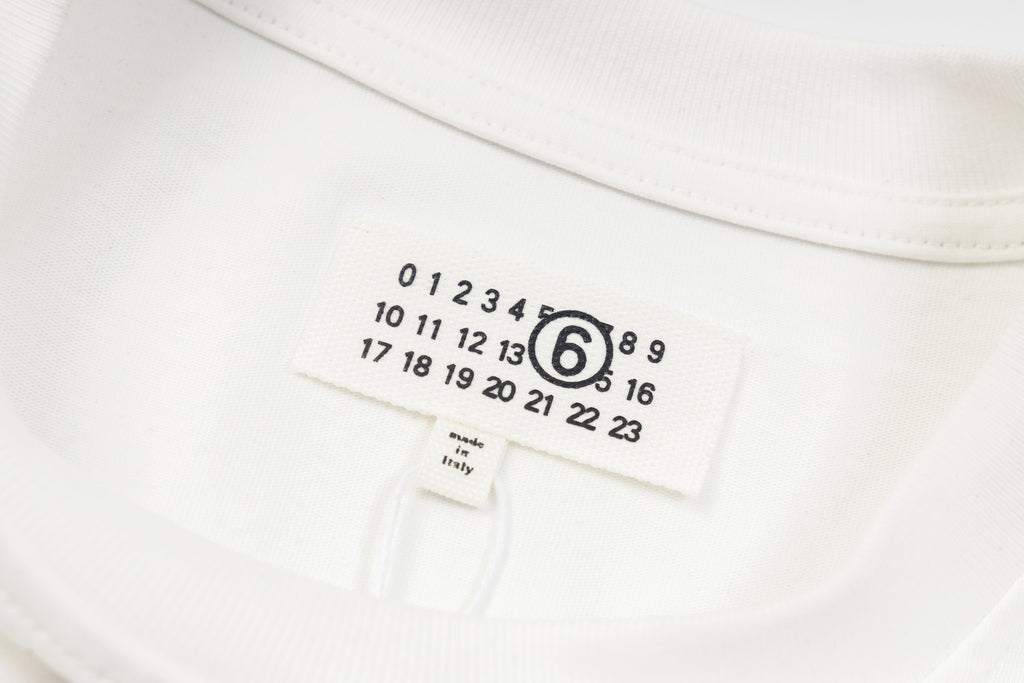 White long-sleeve T-shirt neckline label with size numbers and brand mark