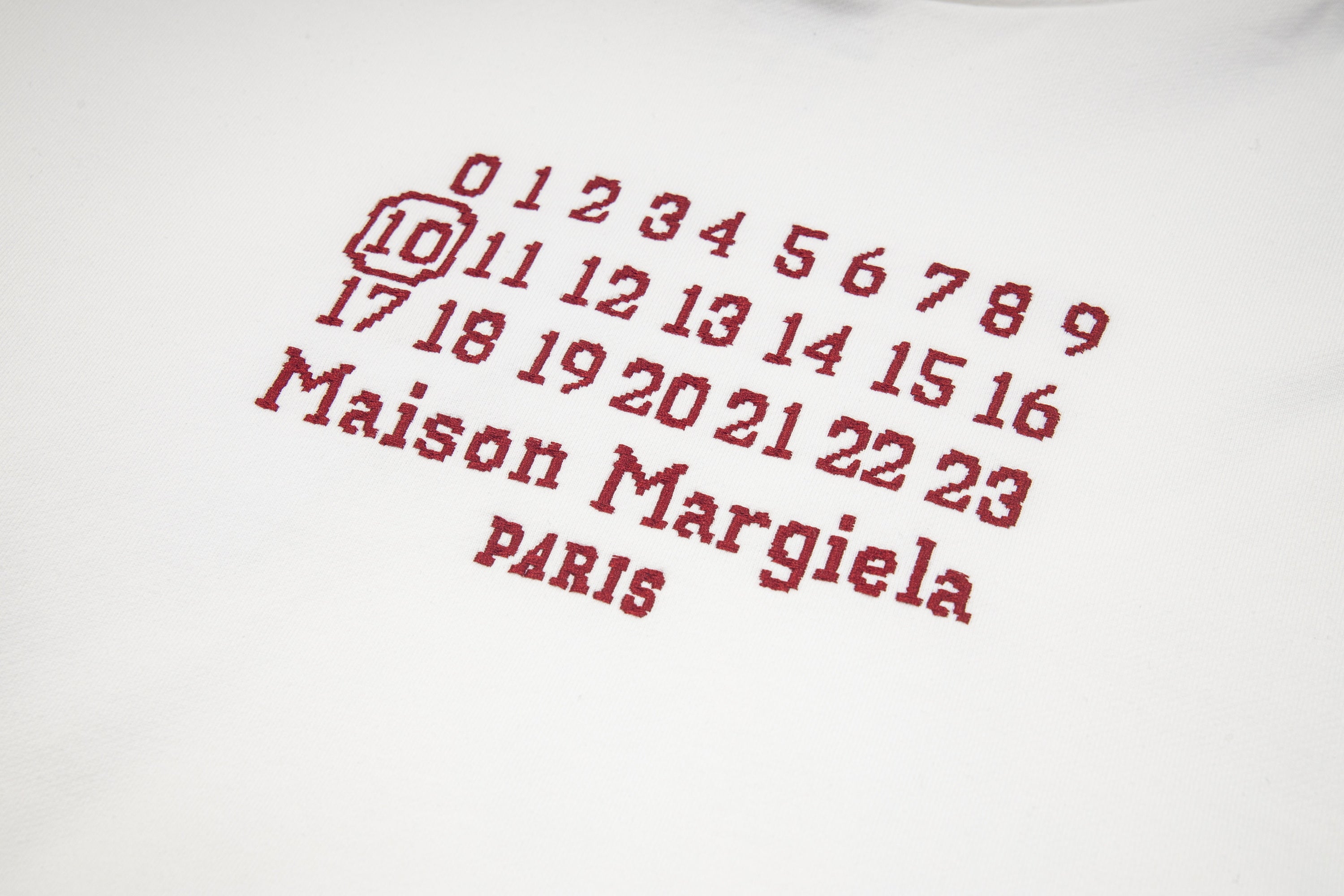Black Maison Margiela hoodie with red number grid and "Maison Margiela" text