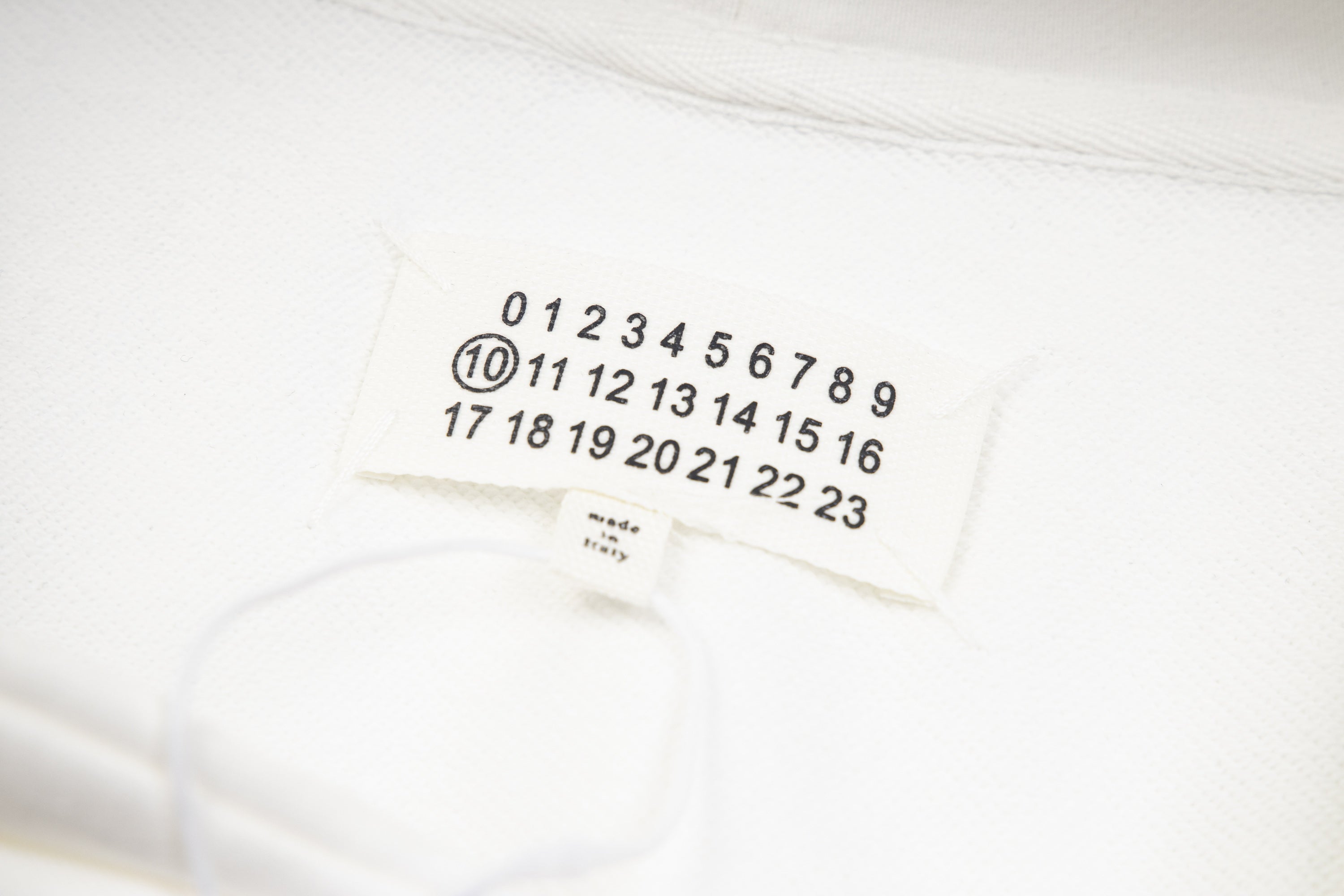 White hoodie fabric with small tag showing number sequence