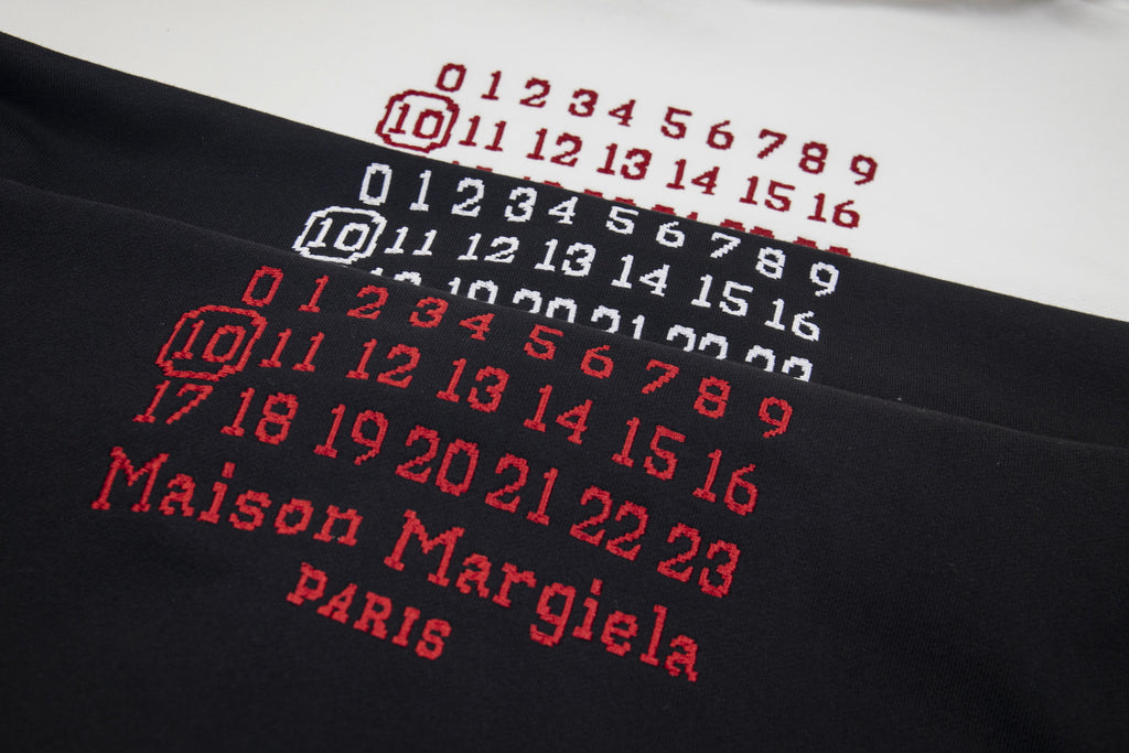 Black hoodie with red number grid and "Maison Margiela" lettering on chest