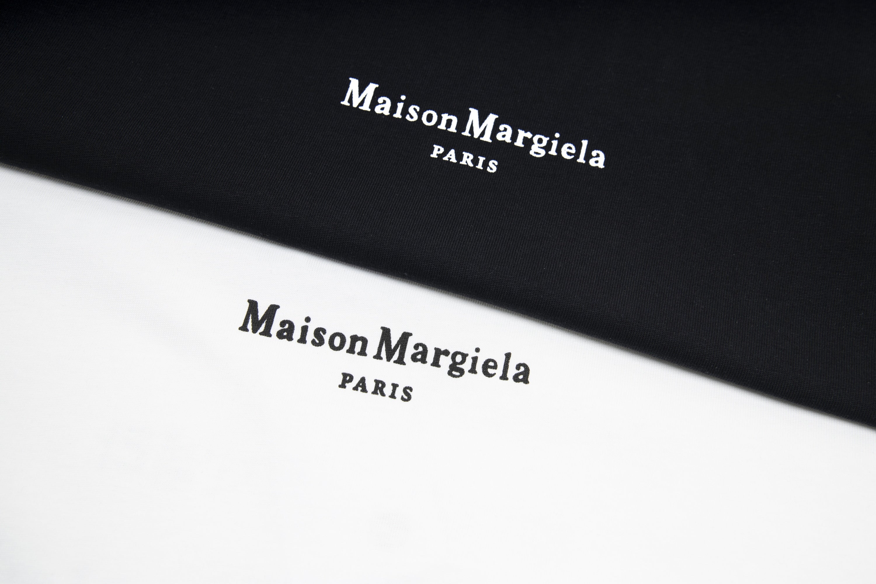 Black T-shirt fabric with Maison Margiela PARIS logo print