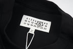 Black T-shirt with Maison Margiela logo size tag at collar