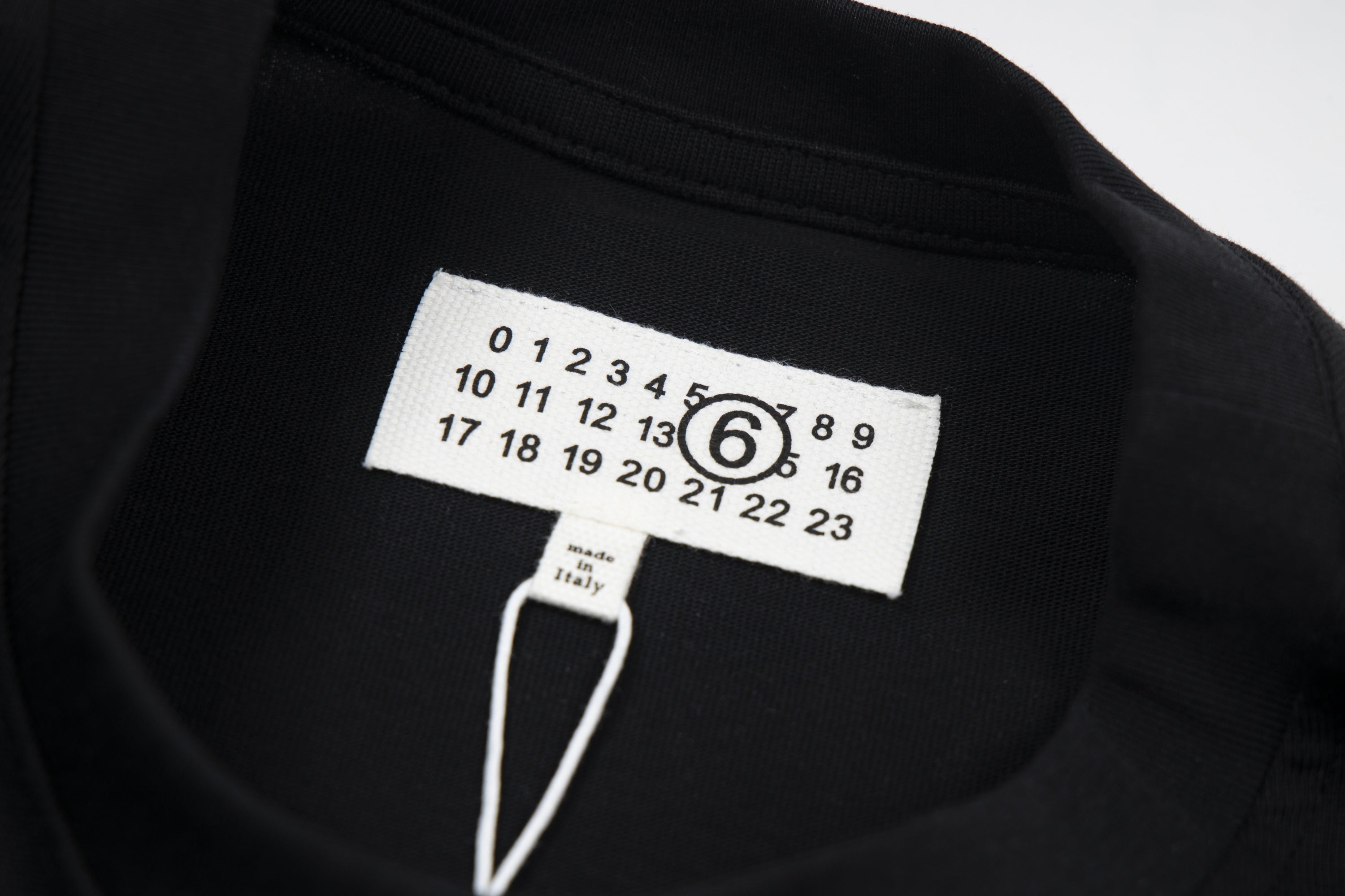 Black T-shirt with Maison Margiela logo size tag at collar
