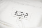 Maison Margiela fabric label with numbered scale, shown on white hood lining