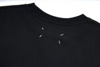 Black T-shirt neckline with small white graphic marks