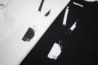 Close-up of black and white Maison Margiela T-shirts with abstract paint stripe print