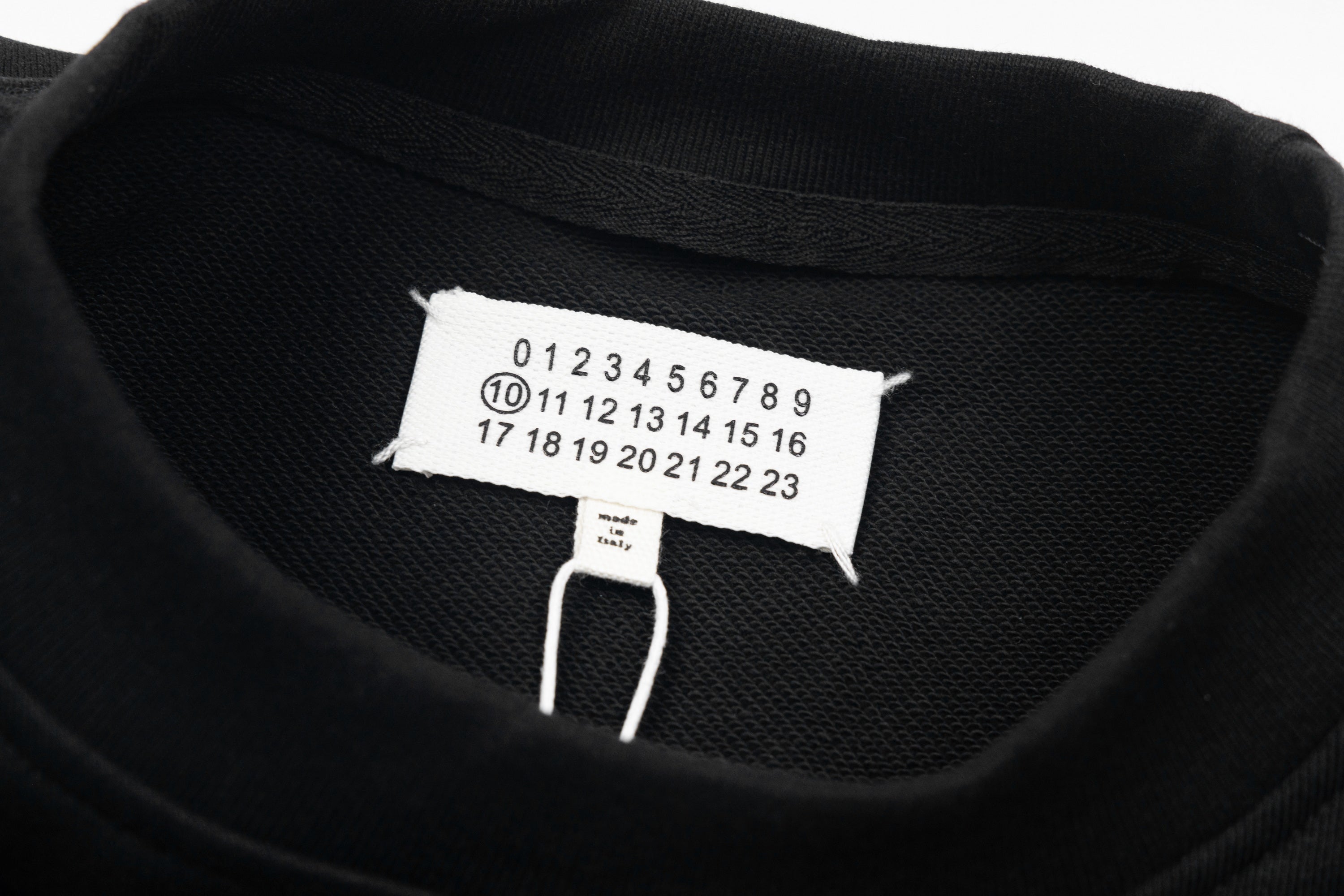 Black sweatshirt neckline with size label and hang tag