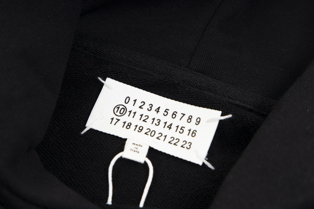 Black hoodie neck tag with size numbers and white drawstrings