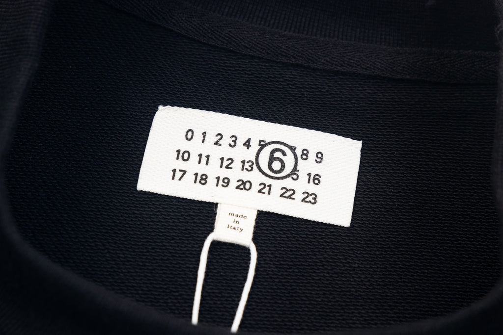 Black sweatshirt neckline label with '6' number graphic and size tag