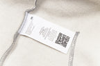 Care and QR label on heather grey hooded sweatshirt hem