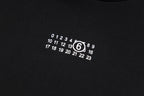 Black hoodie chest graphic with circular numeric logo print
