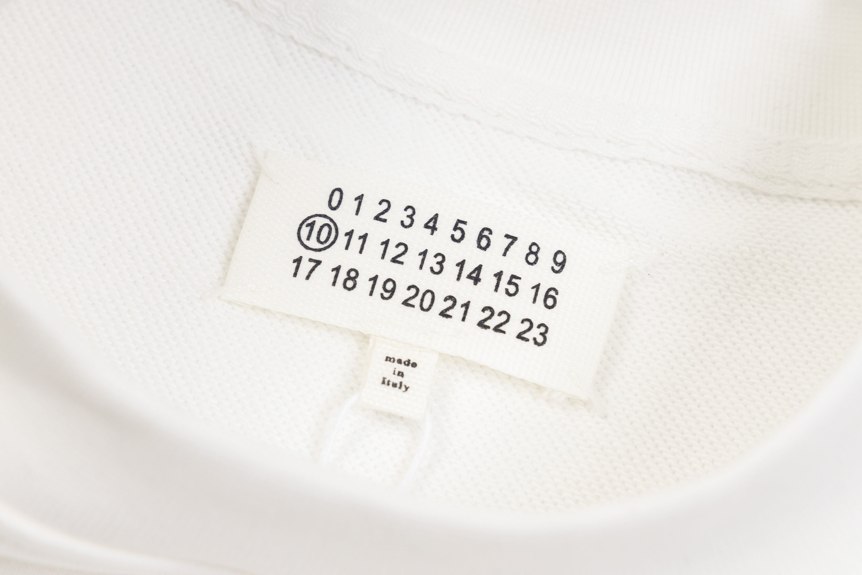 White sweatshirt neck label with size numbers and Maison Margiela text