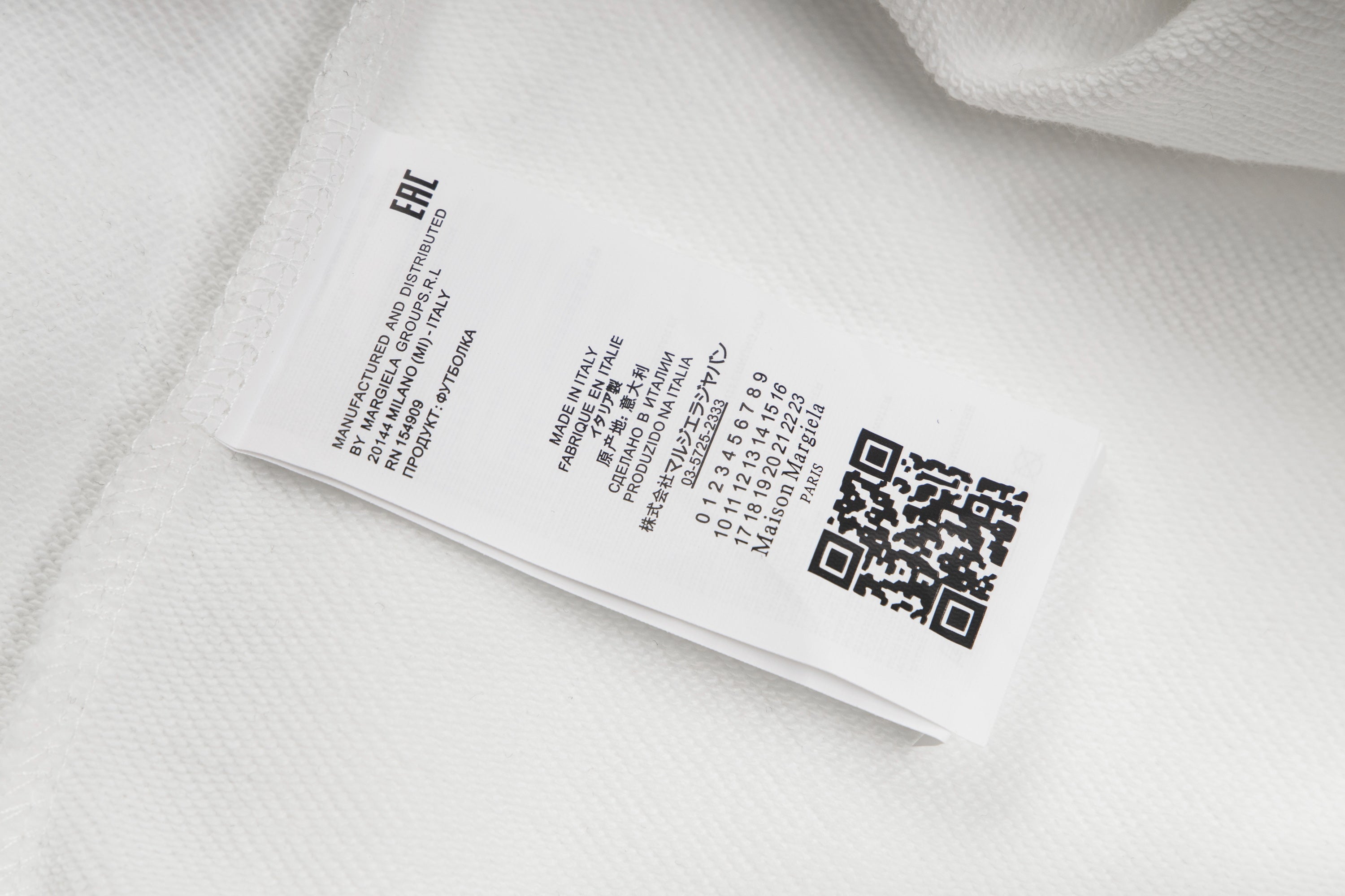 White hoodie care label on inner seam with barcode