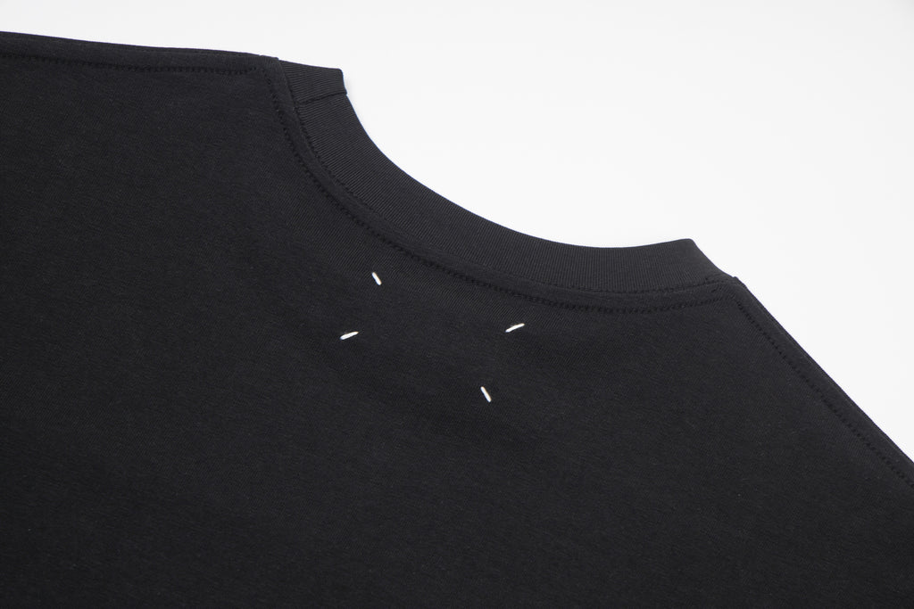 Black crewneck T-shirt with small decorative marks near neckline