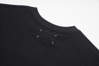 Black crewneck T-shirt with small decorative marks near neckline