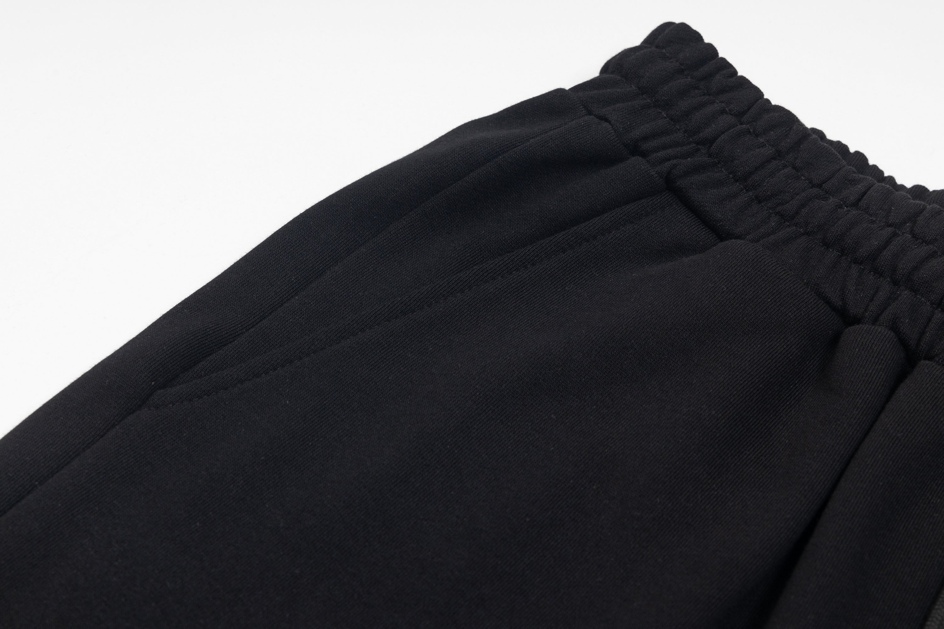 Black elastic waistband and gathered fabric hem close-up
