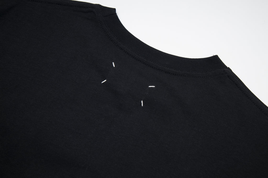 Black Maison Margiela T-shirt close-up of crew neck and small logo detail.