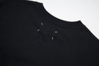 Black Maison Margiela T-shirt close-up of crew neck and small logo detail.