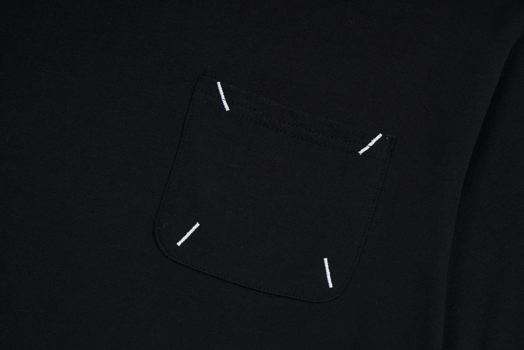 Black T-shirt chest pocket area with visible topstitch and small stitch details