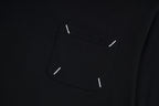 Black T-shirt chest pocket area with visible topstitch and small stitch details