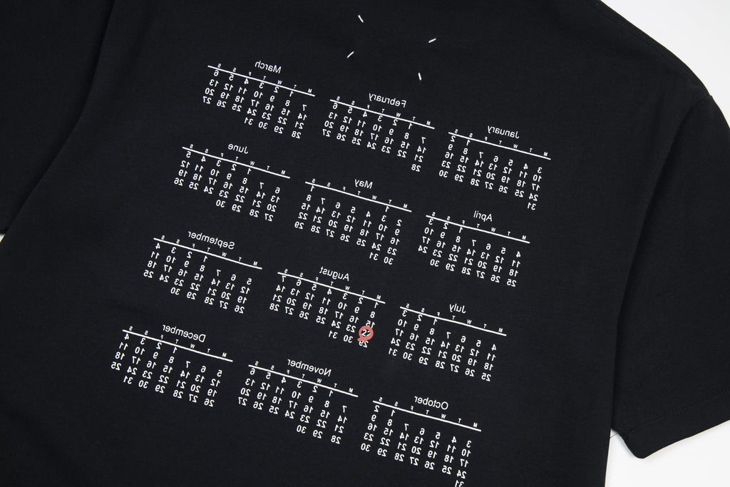 Black T-shirt close-up with white grid of numbers print