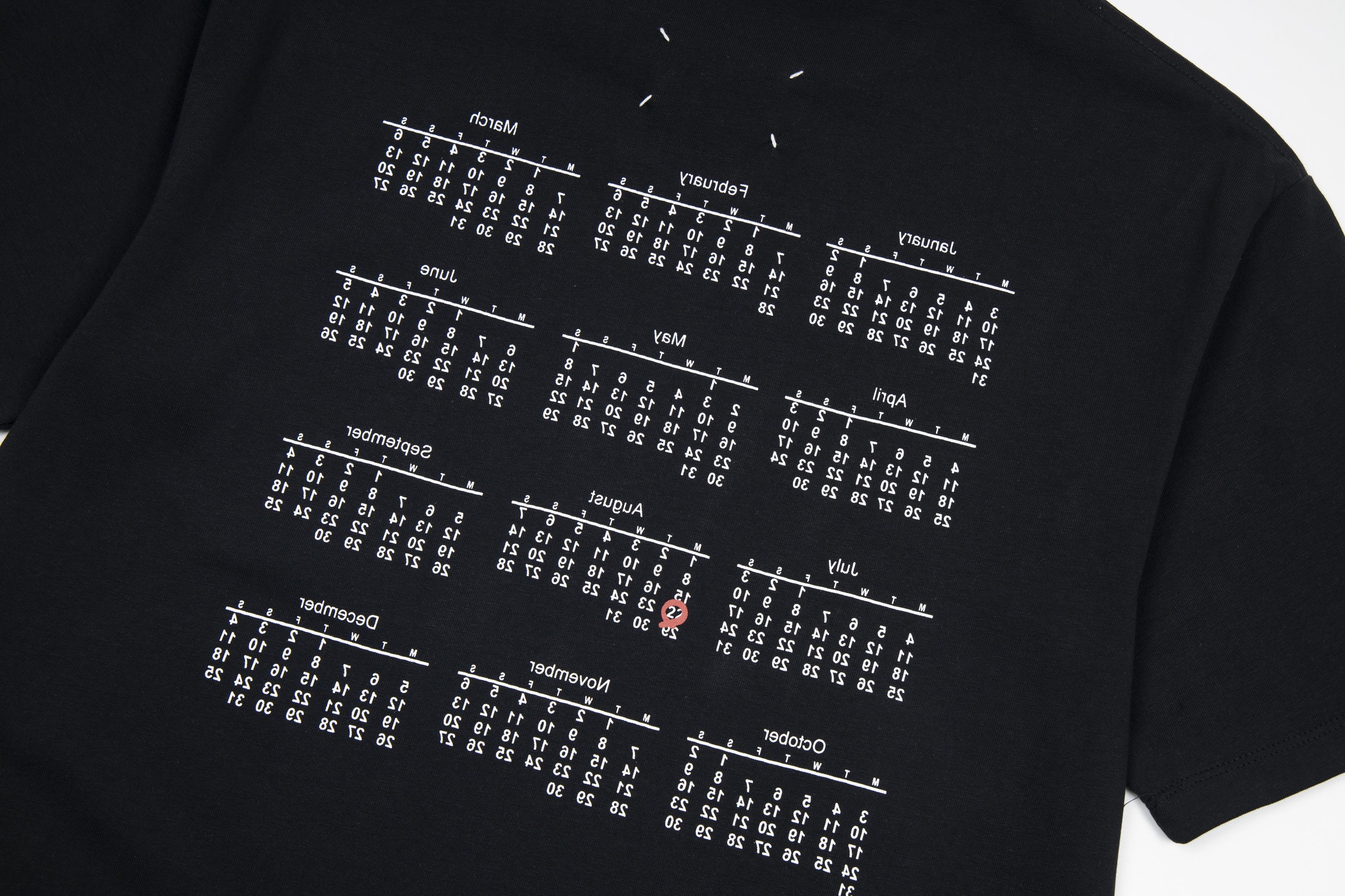Black T-shirt close-up with white grid of numbers print