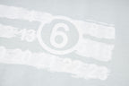 Close-up of Maison Margiela '6' logo print on light fabric