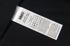 Black T-shirt fabric label with care information and MM6 code
