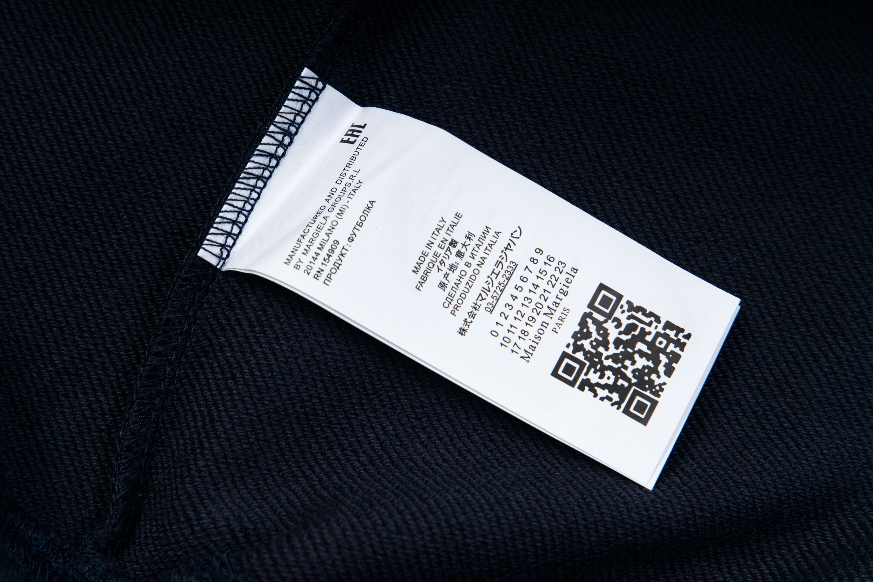 Dark fabric care label with printed size and QR code