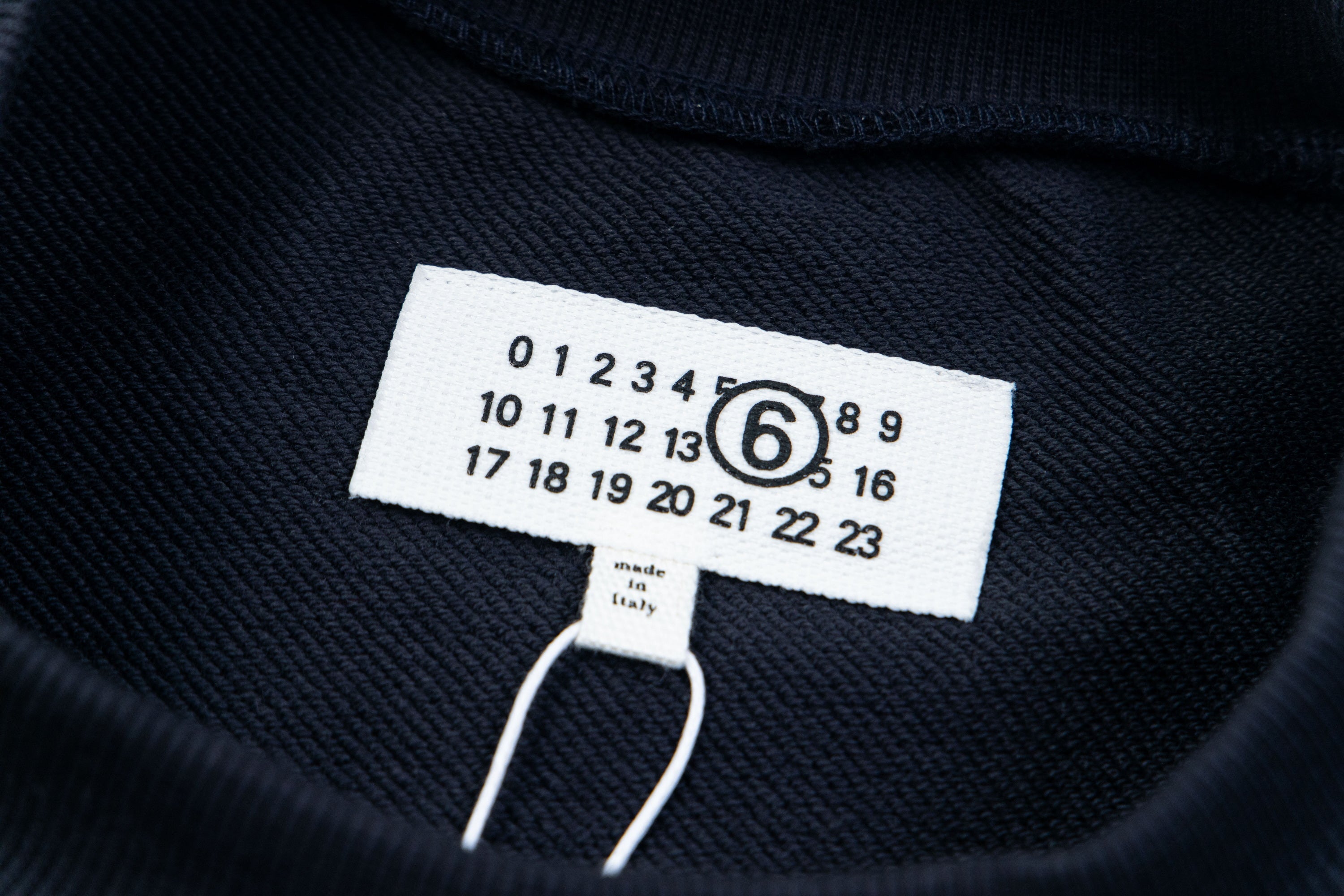 Dark sweatshirt neckline tag with size and care text