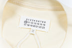 Cream T-shirt neckline and hem label with graphic number print