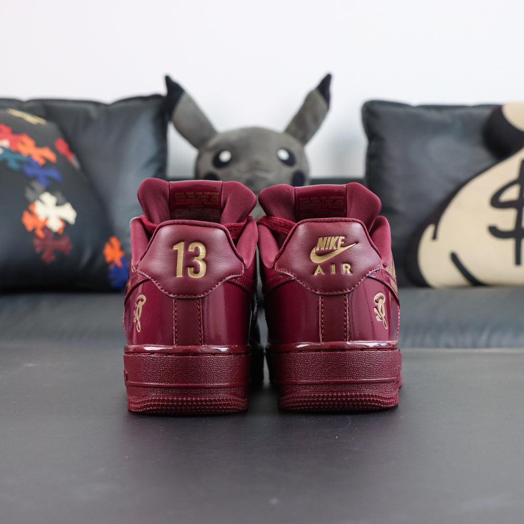 Burgundy low-top sneakers from back, showing '13' heel and Nike Air tongue