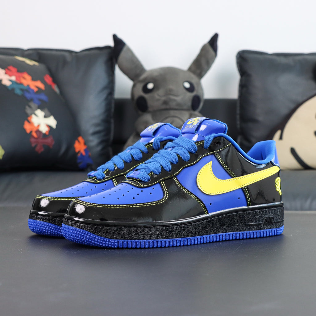 Nike Air Force 1 low-top sneakers, blue and black with yellow Swoosh; front view.