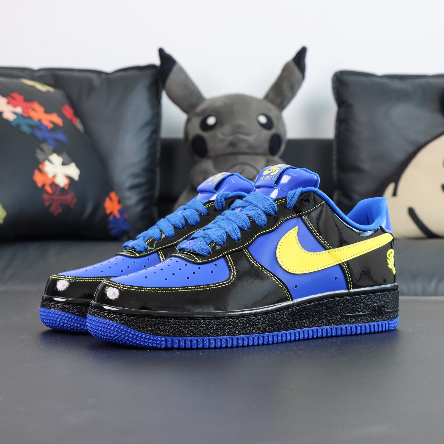 Nike Air Force 1 low-top sneakers, blue and black with yellow Swoosh; front view.