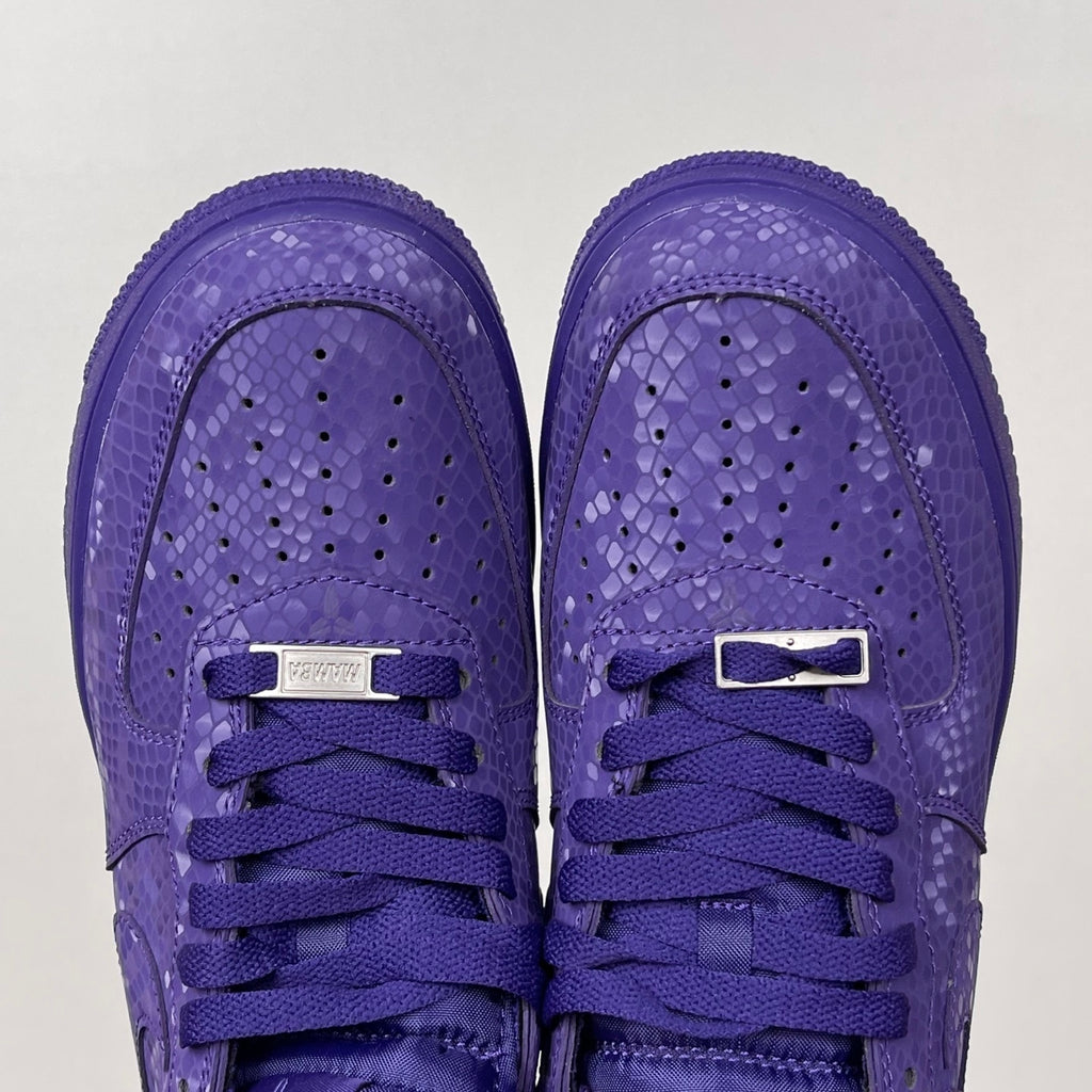 Pair of purple low-top sneakers with lace-up closure and perforated toe area