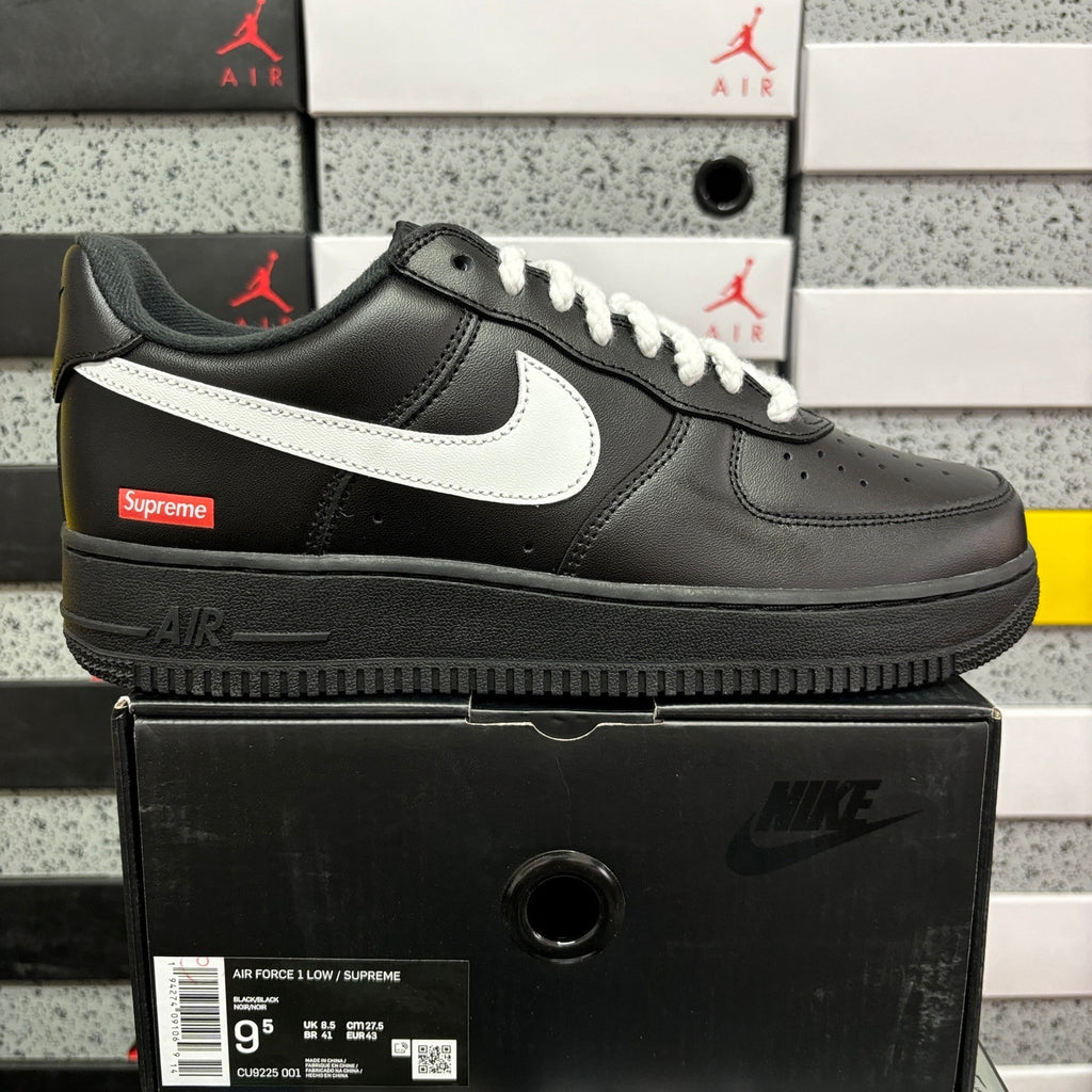 Black low-top sneaker with white swoosh, lace-up front, and thick sole
