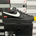 Black low-top sneaker with white swoosh, lace-up front, and thick sole