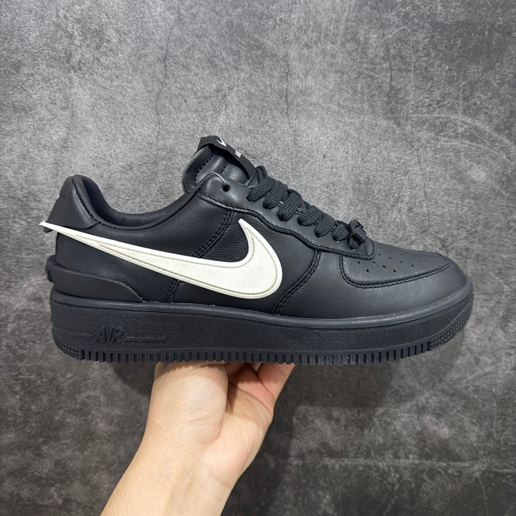Black sneaker with white Nike swoosh, lace-up front, and chunky rubber sole